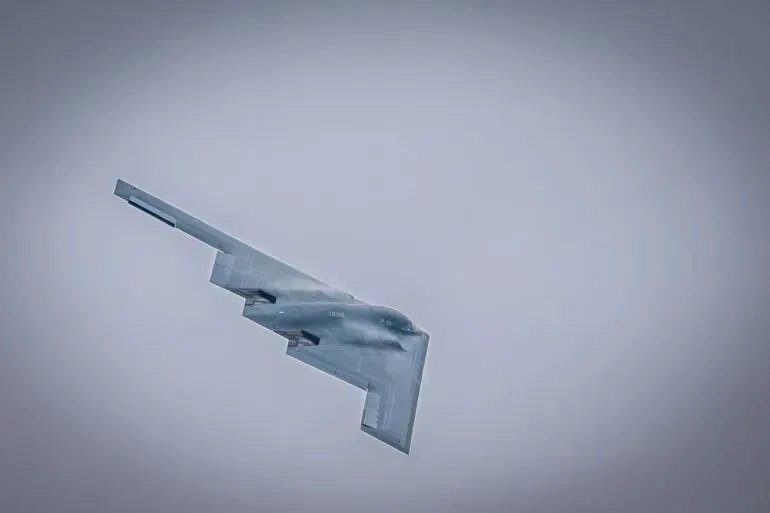 قاذفة قنابل B-2 شبحية تحلق في السماء، تمثل القوة العسكرية الأمريكية في سياق تصعيد التوترات مع إيران بعد الضربات النووية.