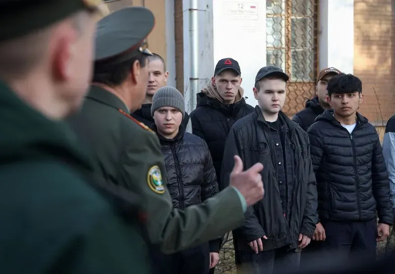 مجموعة من الشبان يستمعون إلى ضابط عسكري خلال تجنيدهم المحتمل، مما يعكس التوترات المستمرة في الصراع الأوكراني.