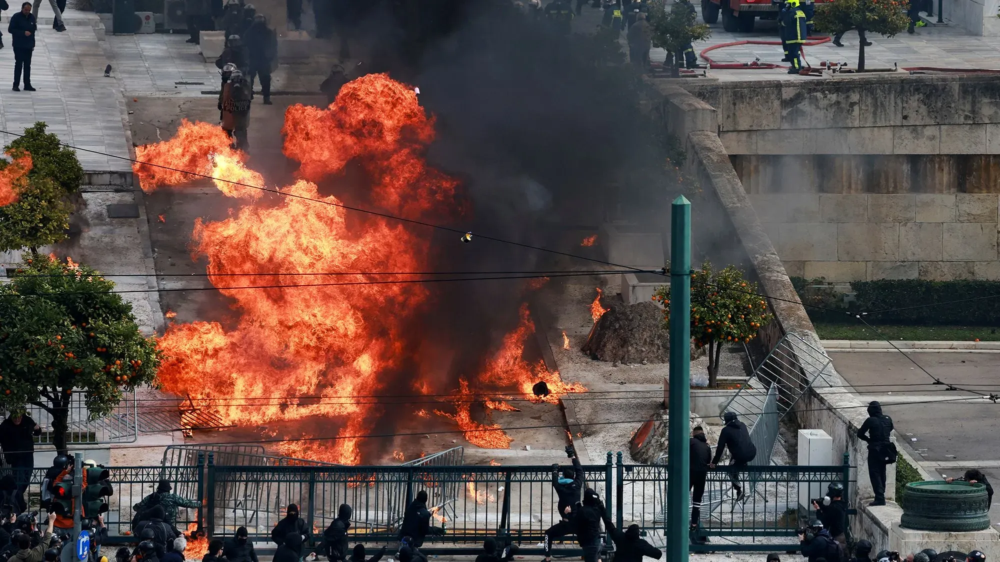 احتجاجات في أثينا حيث تتصاعد النيران وسط حشود المتظاهرين، مطالبين بالعدالة بعد حادث تحطم القطار المأساوي.
