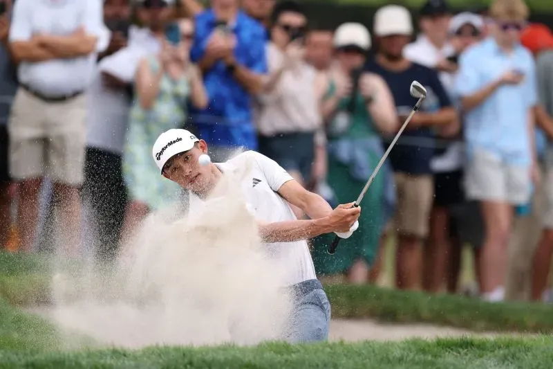 كولين موريكاوا يضرب الكرة من الرمال في بطولة اللاعبين، بينما يشاهد الجمهور من حوله، مع التركيز على أدائه المذهل.