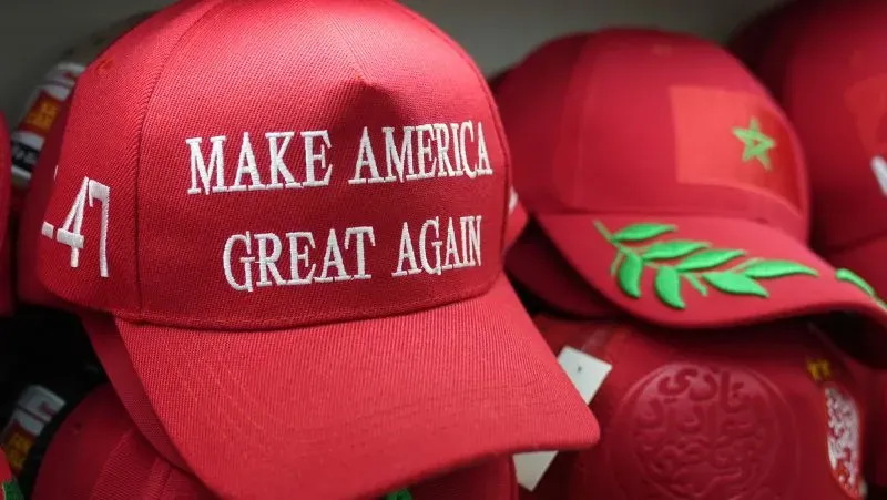 قبعات حمراء مكتوب عليها "اجعلوا أمريكا عظيمة مرة أخرى"، تُعرض في سوق ييوو، مركز تصدير زينة عيد الميلاد إلى الولايات المتحدة.