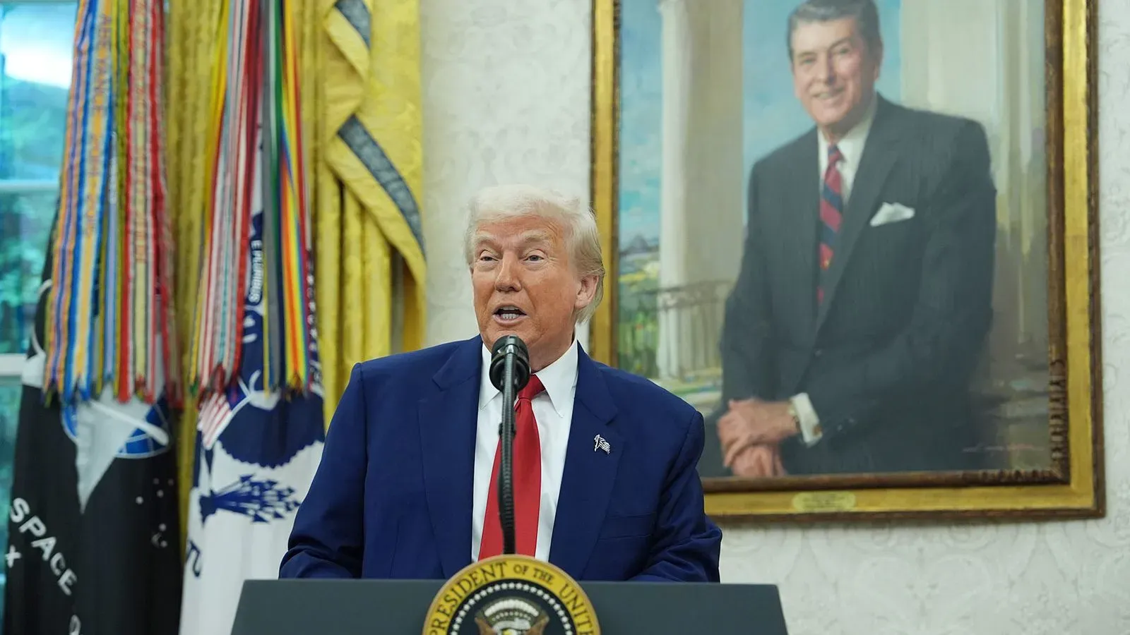 ترامب يتحدث في المكتب البيضاوي، مع صورة للرئيس ريغان خلفه، يتناول قضايا أوكرانيا والعلاقات مع روسيا.
