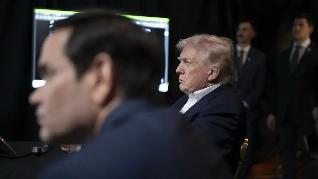 ترامب يجلس مع مستشاره ماركو روبيو أثناء متابعة عملية القبض على مادورو في مار-أ-لاغو، مع شاشات تعرض تفاصيل المهمة.