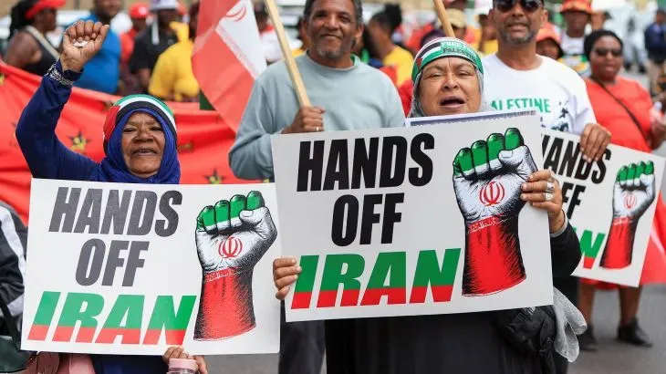 محتجون يحملون لافتات تعبر عن دعمهم لإيران، مع شعارات تدعو إلى عدم التدخل في شؤونها، في سياق الاحتجاجات ضد الحرس الثوري الإيراني.