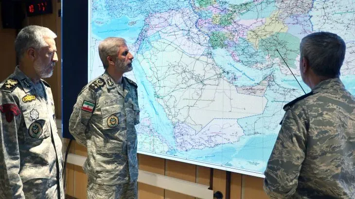 ضباط إيرانيون يتابعون خريطة استراتيجية للمنطقة، في سياق التصعيد العسكري ضد إسرائيل والتهديدات الأمريكية.