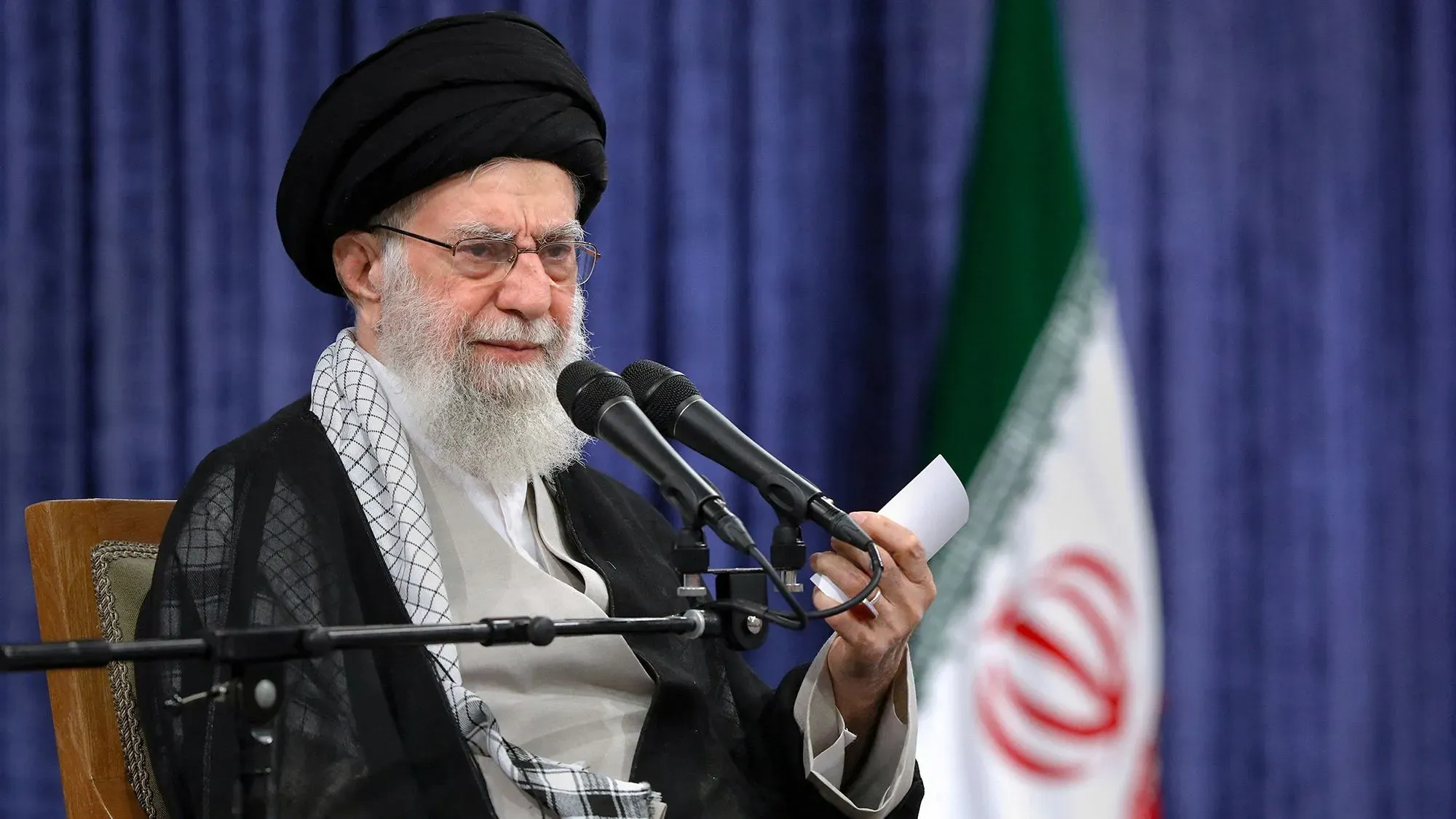المرشد الأعلى الإيراني آية الله علي خامنئي يتحدث خلال مؤتمر، مع وجود العلم الإيراني خلفه، معبرًا عن موقفه من المفاوضات النووية مع الولايات المتحدة.