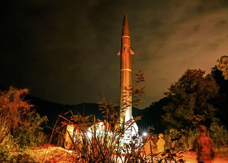 صاروخ صيني في موقع إطلاق ليلي، مع وجود جنود بالقرب منه، يبرز التقدم العسكري للصين تحت قيادة شي جين بينغ.