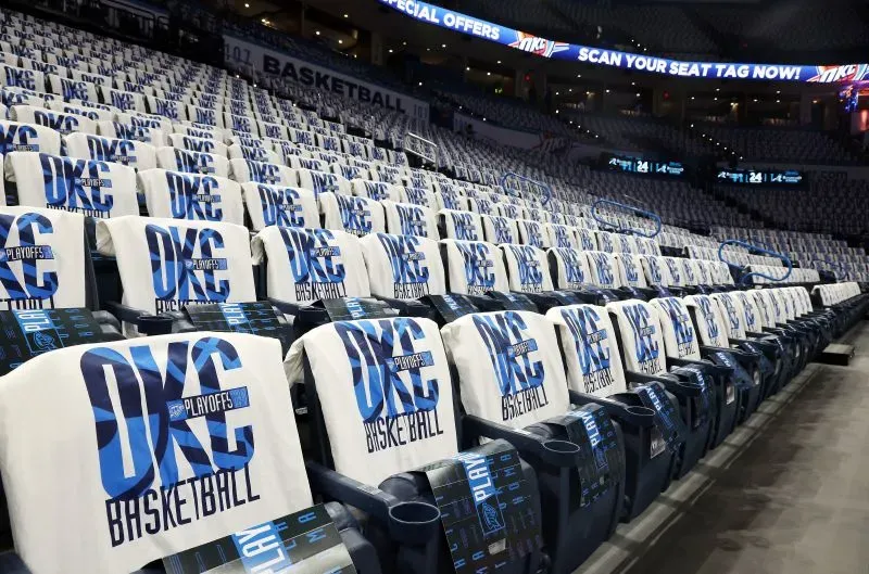 مدرجات ملعب مغطاة بقمصان تحمل شعار "OKC Basketball"، استعدادًا لمباريات البلاي أوف، تعكس أجواء الحماس والتشجيع الجماهيري.