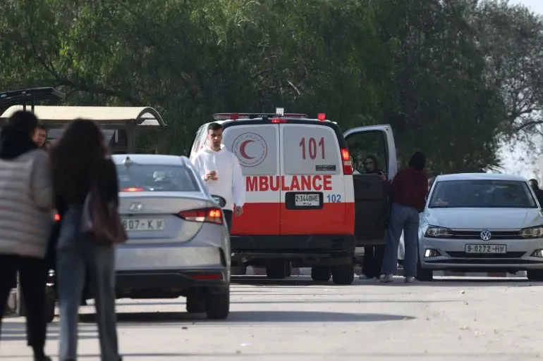 سيارة إسعاف تابعة للهلال الأحمر الفلسطيني متوقفة في موقع الحادث، مع تجمع عدد من الأشخاص حولها في جامعة بيرزيت بعد الهجوم الإسرائيلي.