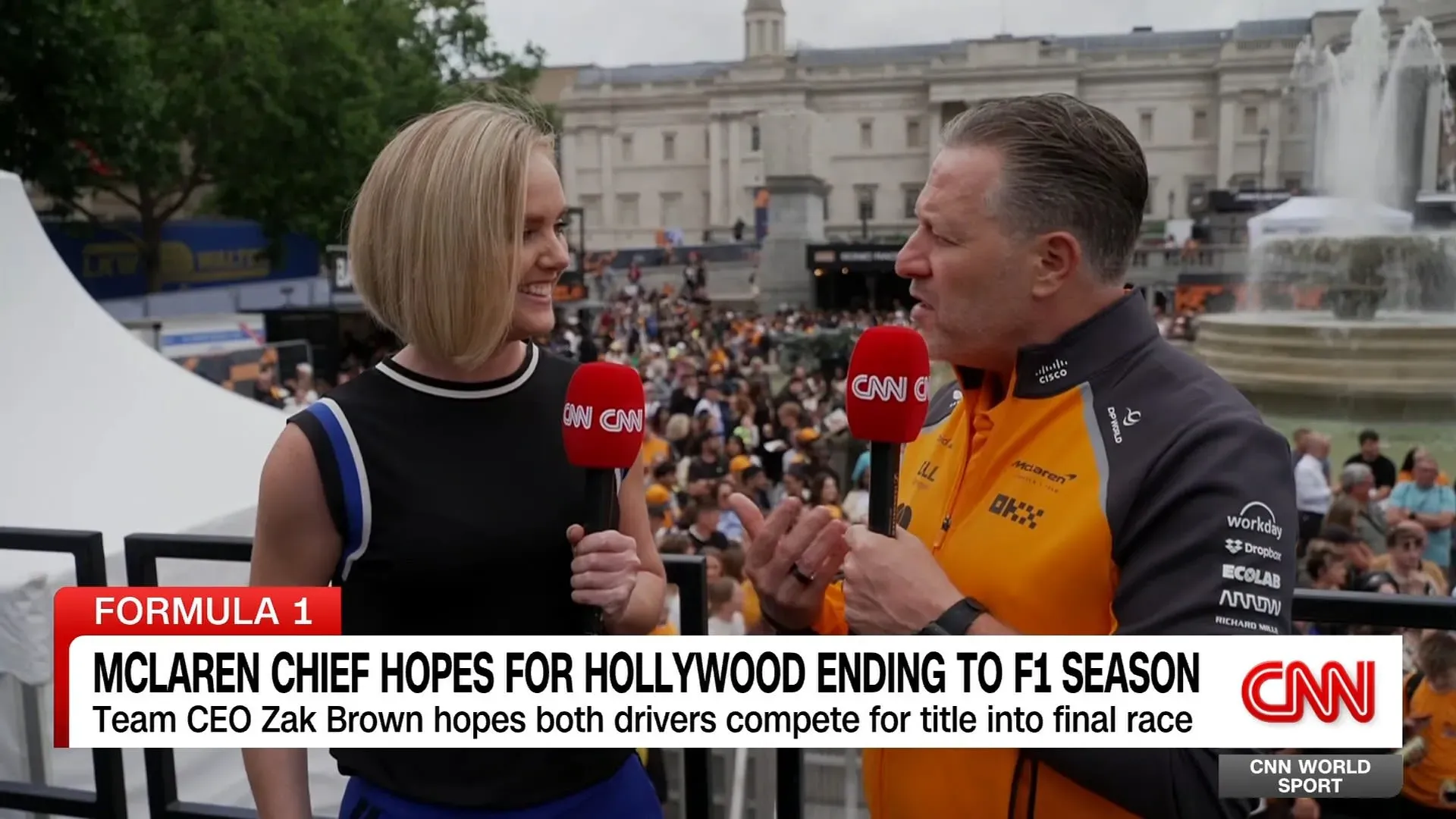 مقابلة مع زاك براون، الرئيس التنفيذي لفريق مكلارين، يتحدث عن آمال الفريق في موسم الفورمولا 1، مع حشد من المشجعين خلفه.