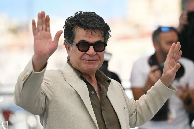 المخرج الإيراني جعفر بناهي يلوح بيده أثناء حضوره مهرجان كان السينمائي بعد فوزه بجائزة السعفة الذهبية عن فيلمه "كانت مجرد حادثة".