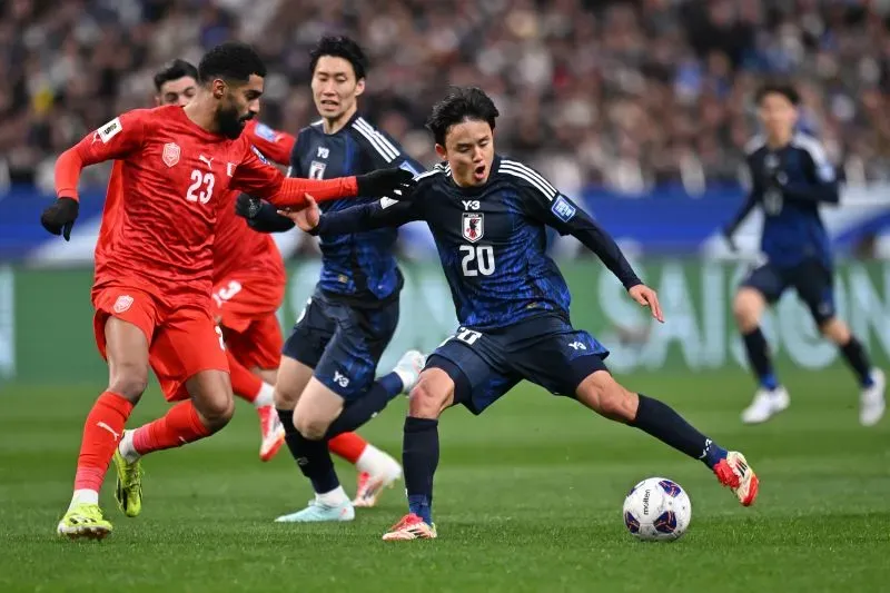 لاعبو منتخب اليابان يتنافسون مع منتخب البحرين خلال مباراة تصفيات كأس العالم 2026، حيث أحرزت اليابان هدفين وحققت التأهل.