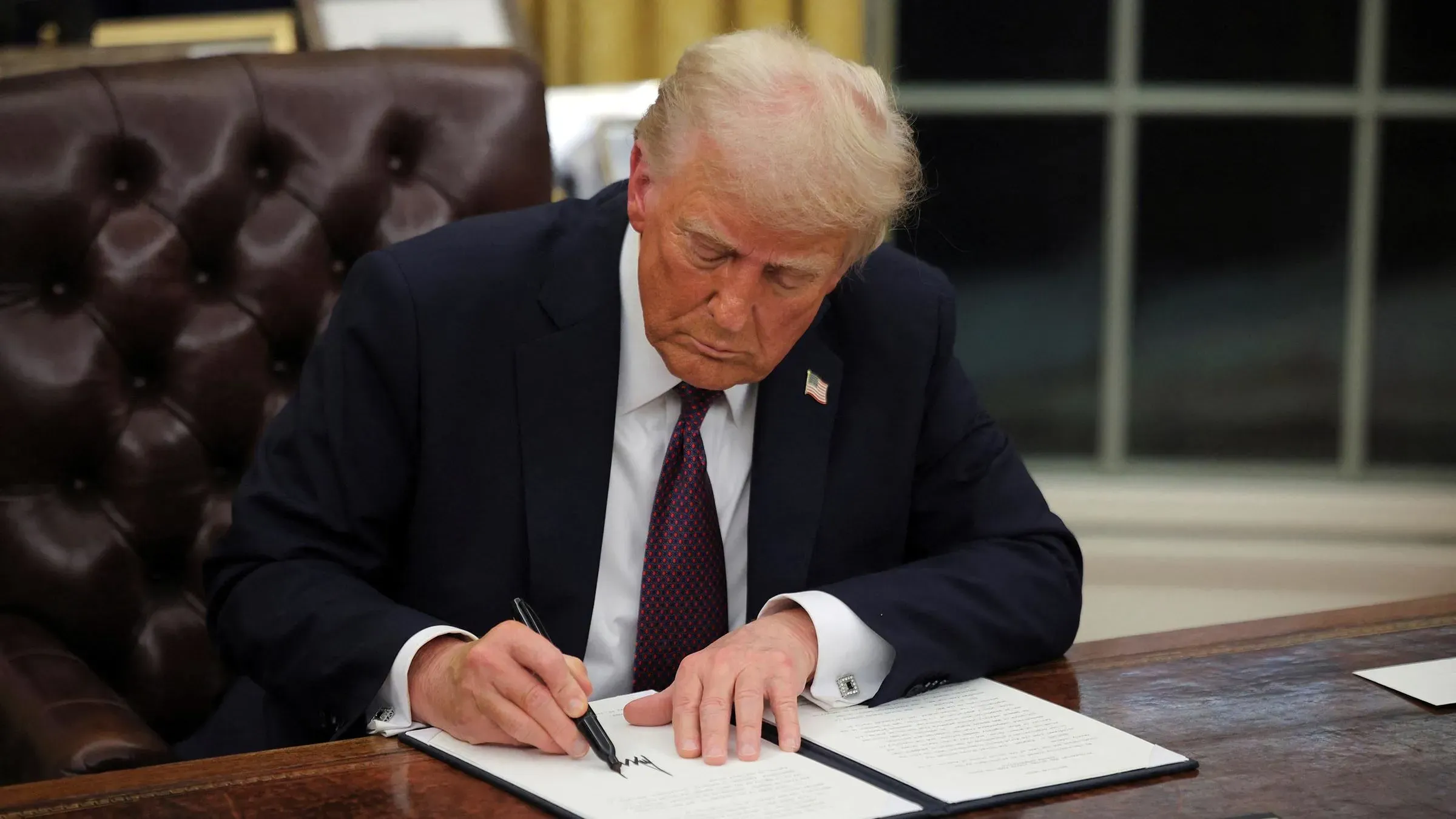 الرئيس ترامب يوقع على أمر تنفيذي في المكتب البيضاوي، ما أدى إلى جدل قانوني حول حق المواطنة بالميلاد وتأثيره على الأطفال.