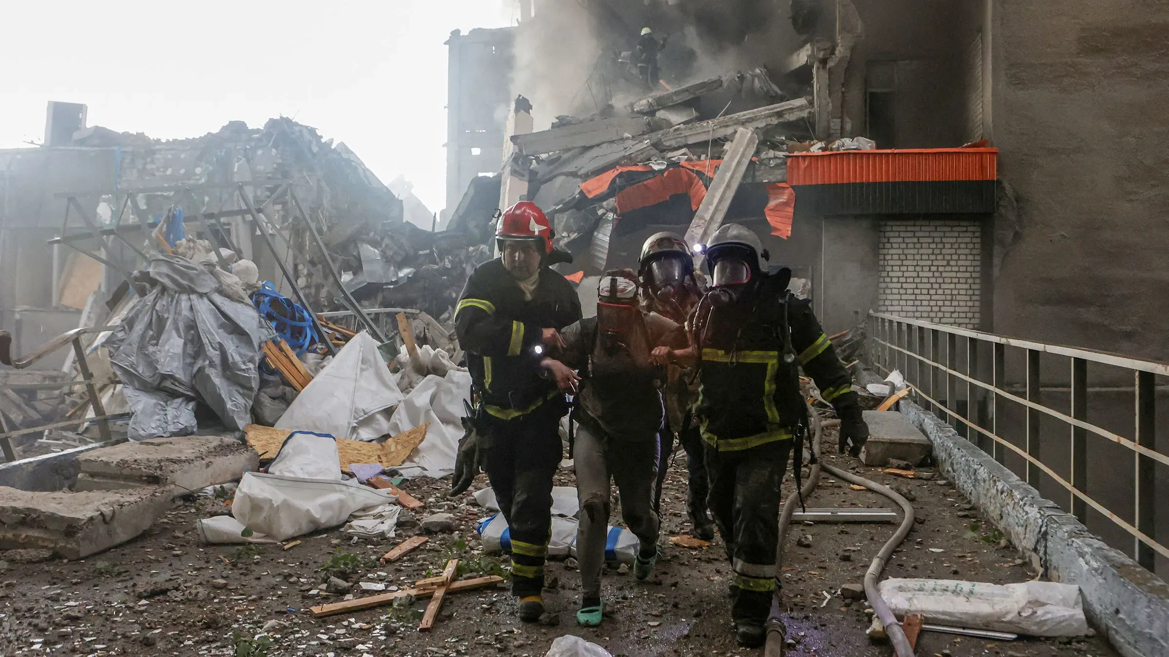 رجال إطفاء ينقلون شخصًا مصابًا من موقع انفجار في مدينة خاركيف، حيث دمرت الضربات الجوية مبنى سكني وأسفرت عن إصابات ووفيات.