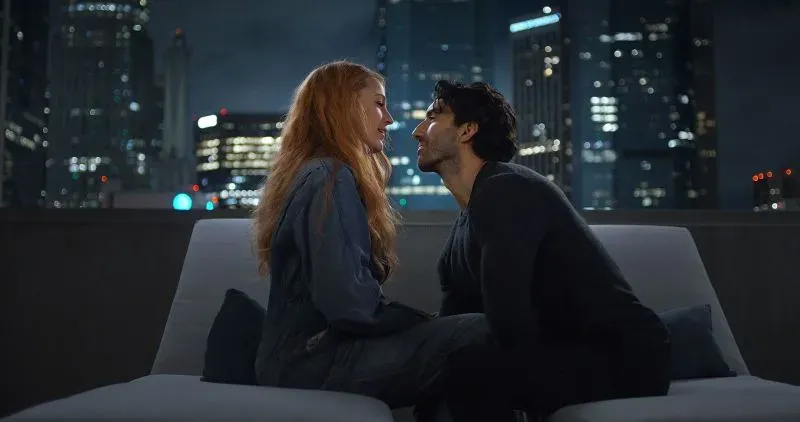 مشهد من فيلم "It Ends With Us" يظهر الممثلة بليك ليفلي والممثل جاستن بالدوني في لحظة عاطفية، مع خلفية لمدينة مضاءة ليلاً.