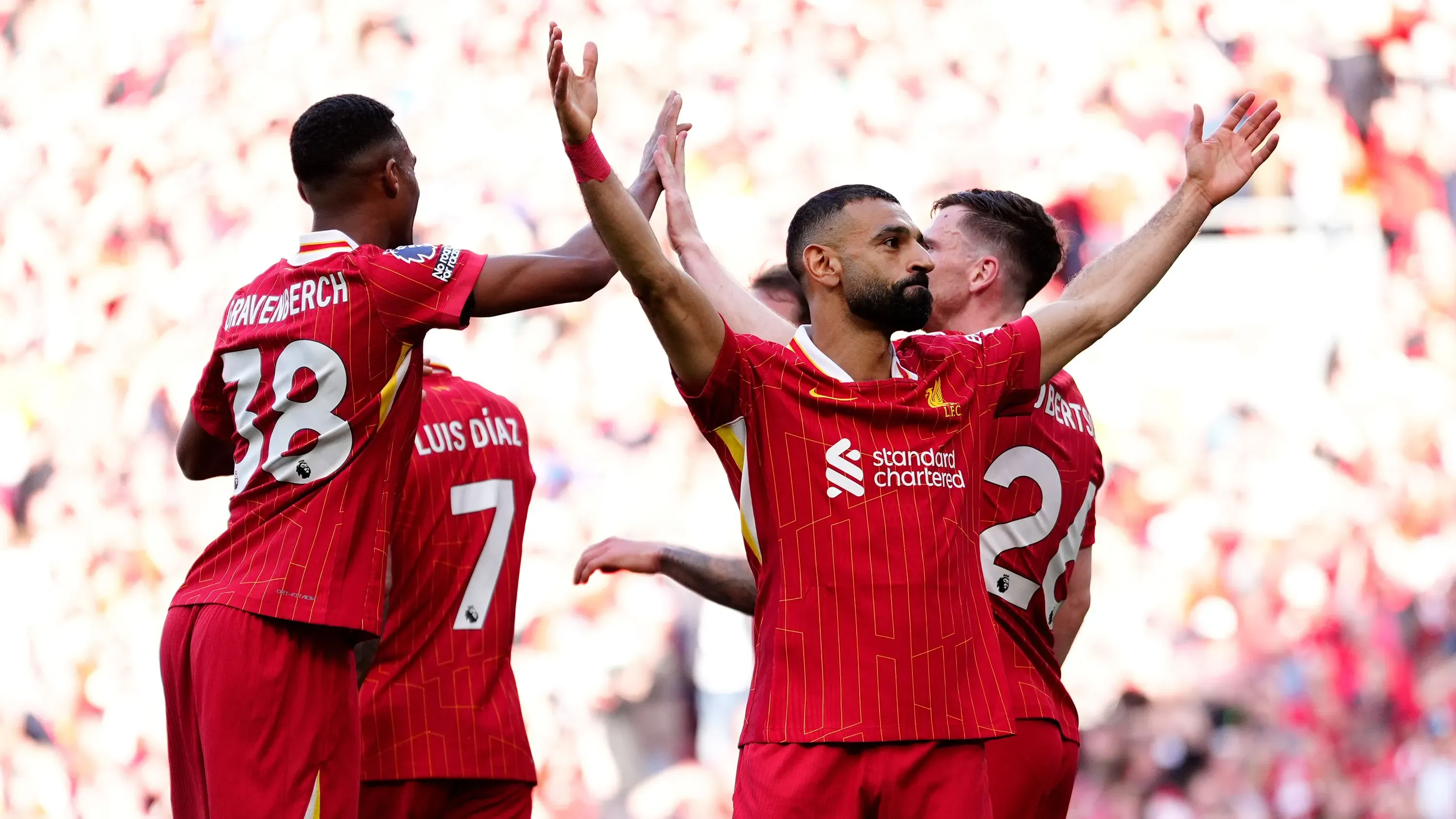 فريق ليفربول يحتفل بفوزهم بلقب الدوري الإنجليزي الممتاز بعد مباراة حاسمة ضد توتنهام، مع مشاركة اللاعبين في لحظة فرح.