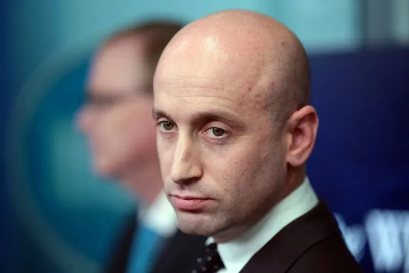 صورة لستيفن ميلر، مستشار سابق للرئيس ترامب، يظهر بملامح جدية أثناء حديثه في مؤتمر صحفي، يعكس التوترات السياسية المتعلقة بالضربات العسكرية.