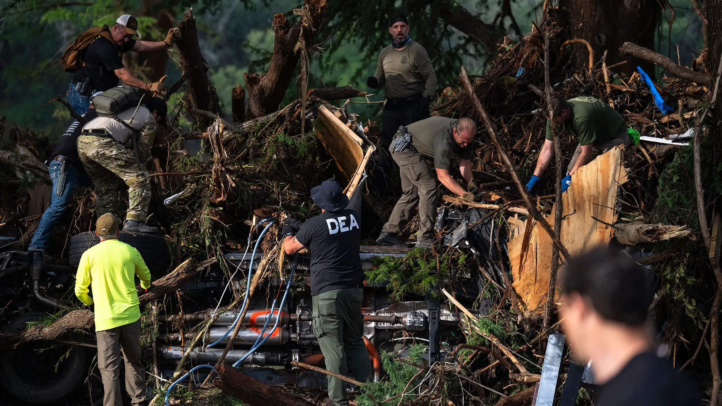 رجال الإنقاذ يعملون على إزالة الحطام بعد الفيضانات في تكساس، حيث تتزايد الأسئلة حول استجابة المسؤولين المحليين للأزمة.