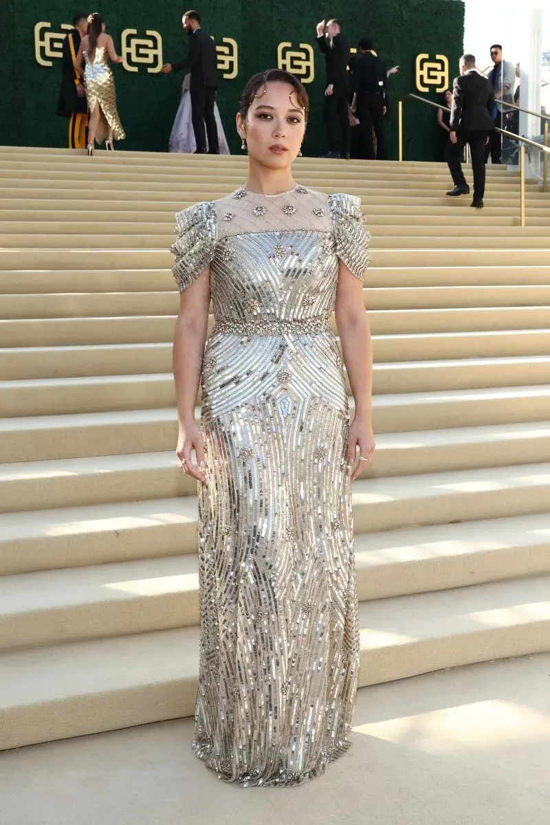 ميغان ثي ستاليون ترتدي فستانًا فضيًا لامعًا بتصميم دراماتيكي في حفل جولد جالا، يعكس تأثيرات الثقافة الآسيوية.