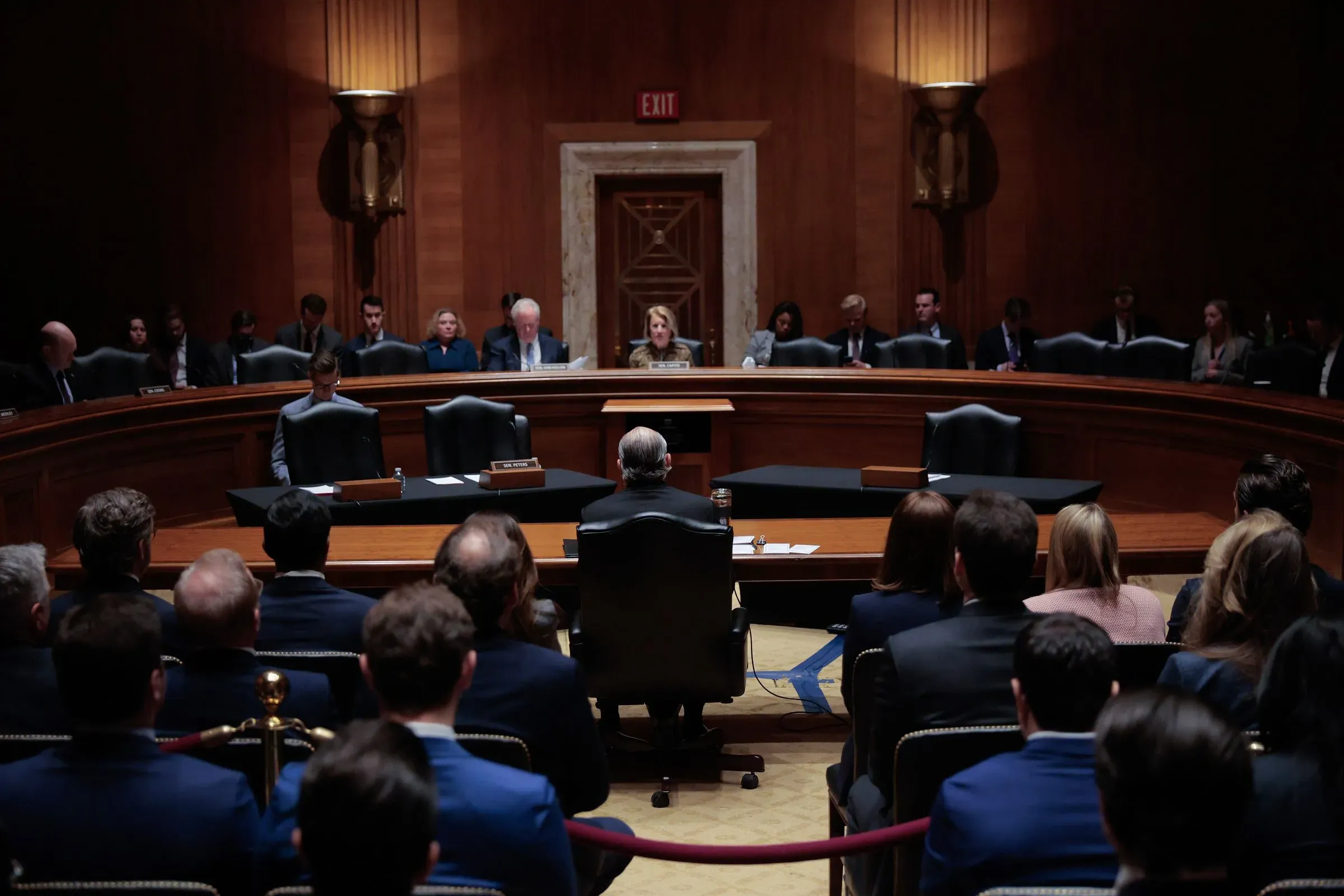 جلسة استماع في مجلس الشيوخ الأمريكي، حيث يجلس عدد من المسؤولين في الصفوف الأمامية بينما يتابع الحضور النقاشات حول قضايا سياسية حساسة.