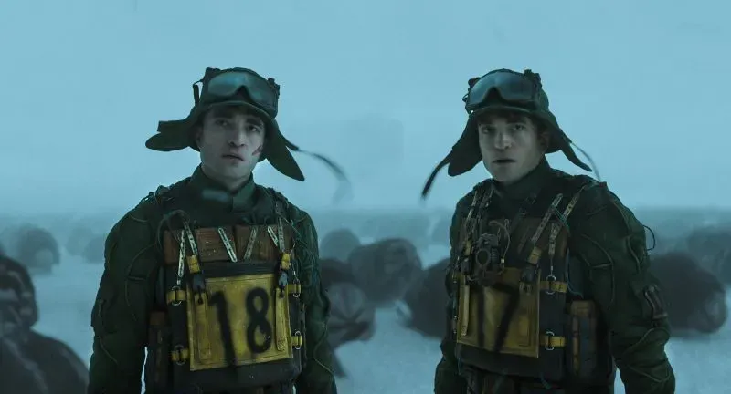 مشهد من فيلم "ميكي 17" يظهر شخصيتين، يرتديان زيًا فضائيًا، في بيئة ثلجية، يعكسان التوتر والمغامرة في قصة الخيال العلمي.