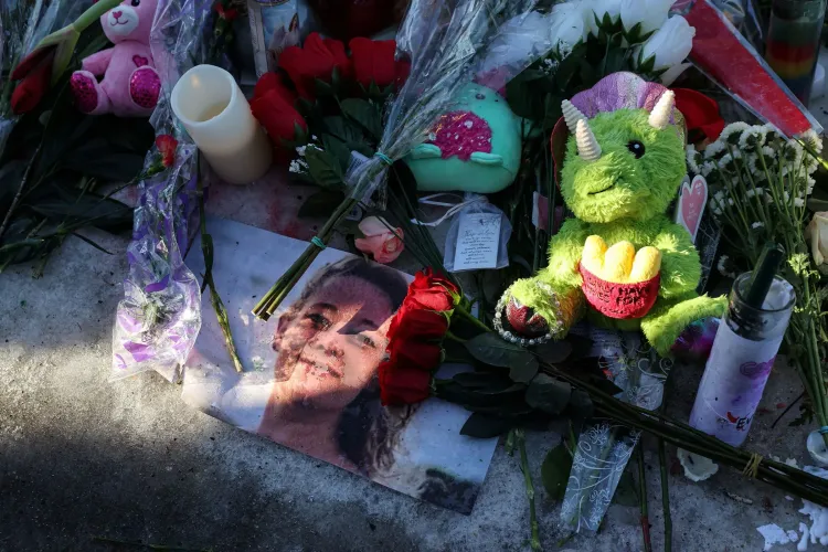 تظهر الصورة تكريمًا لشخص متوفى، مع ورود حمراء، دمى، وشموع، بالإضافة إلى صورة للضحية، مما يعكس الحزن والألم الناتج عن الحادثة.