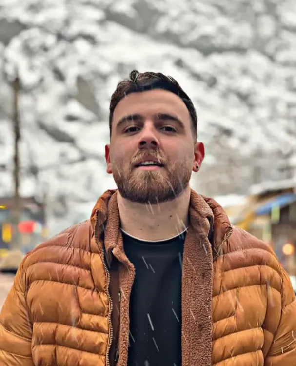 عرفان سلطاني، المتظاهر الإيراني المحتجز، يظهر في صورة أثناء تساقط الثلوج، مع خلفية جبلية، ويبدو في صحة جيدة.