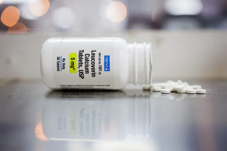 عبوة دواء ليوكوفورين معبأة بجوار أقراص بيضاء على سطح معدني، تشير إلى استخدامه لعلاج نقص الفولات الدماغي.