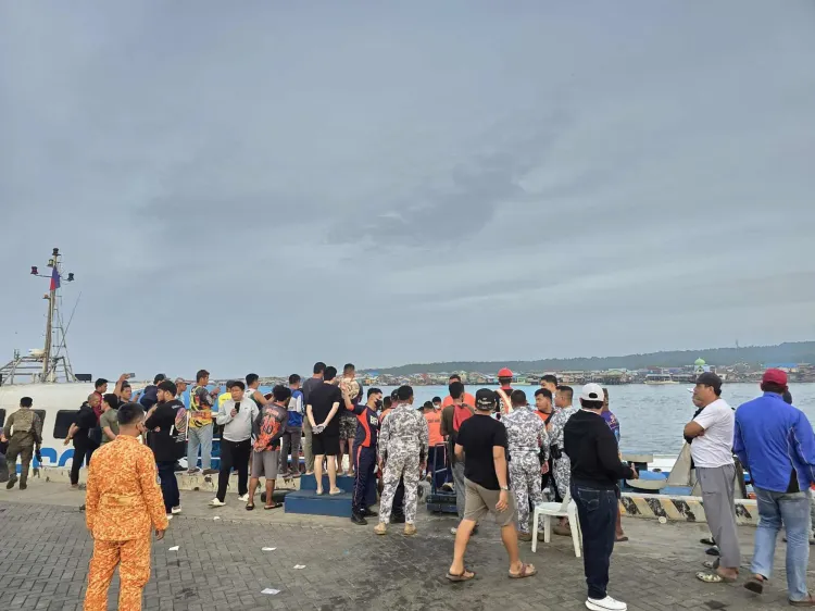 مجموعة من الأشخاص على الرصيف بعد غرق العبارة "إم/في تريشا كيرستين 3" في الفلبين، حيث تم إنقاذ العديد من الركاب.