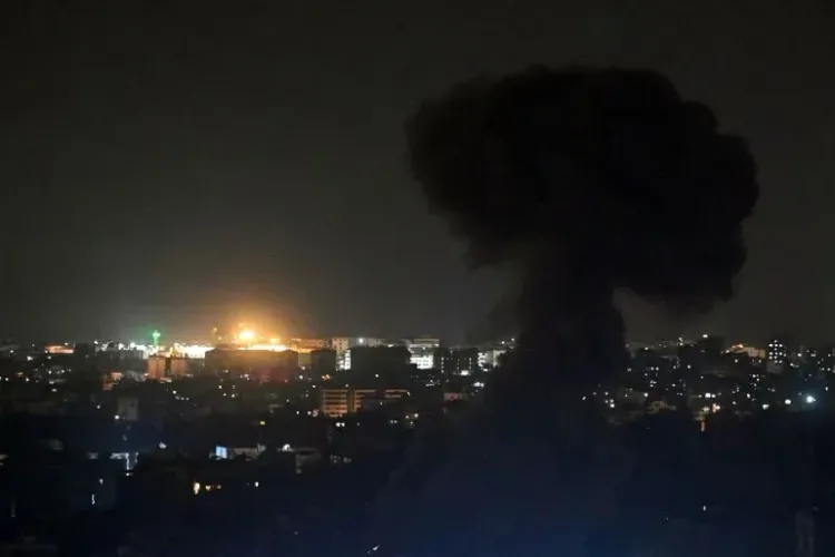 دخان أسود يتصاعد في سماء بيروت ليلاً، مع أضواء ساطعة في الخلفية، تعكس استمرار الهجمات الإسرائيلية على لبنان.