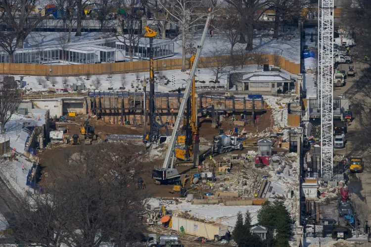 مشهد لموقع بناء قاعة احتفالات جديدة بقيمة 400 مليون دولار بالقرب من البيت الأبيض، يظهر المعدات والعمال في موقع العمل.