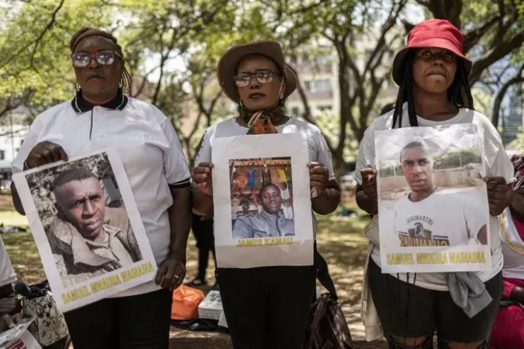 عائلات كينية تحمل صورًا لأحبائها المفقودين في أوكرانيا خلال احتجاج في نيروبي للمطالبة بعودتهم بعد تجنيدهم بشكل غير قانوني.