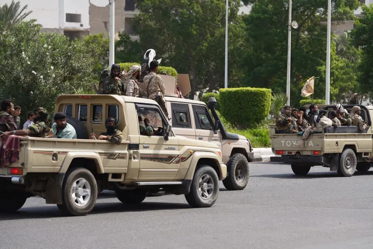 قافلة من المركبات العسكرية تحمل جنوداً في شوارع مدينة عدن، تعكس التحركات الأمنية بعد تصاعد التوترات بين القوات المدعومة من السعودية والإمارات.