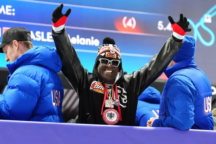 مغني الراب فليفور فلافور يحتفل بفوز فريق الهوكي الأولمبي الأمريكي، مرتديًا ملابس ملونة ومجوهرات لامعة، بينما يظهر خلفه أعضاء الفريق.