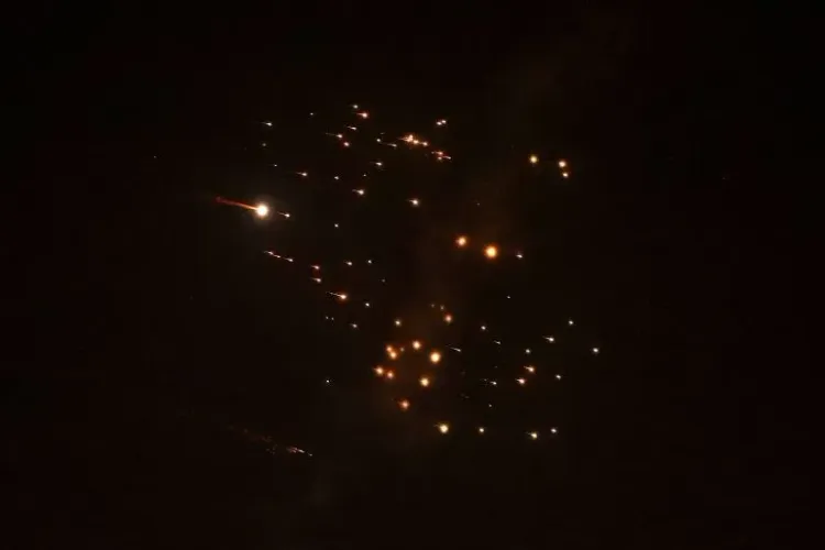 شظايا صاروخية تتساقط في السماء ليلاً، مما يعكس الأثر المدمر للهجمات الإيرانية على المناطق الفلسطينية، حيث قُتلت ثلاث نساء في صالون.