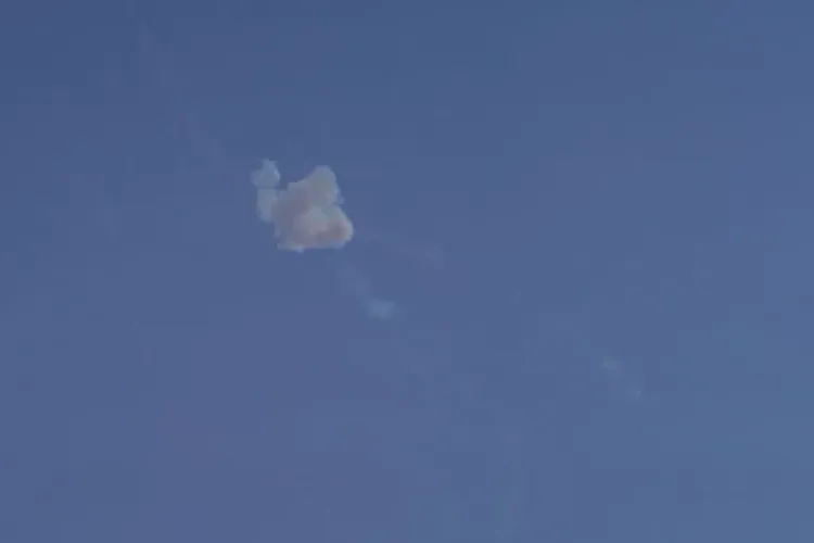 سحابة دُخانية تتصاعد في السماء الزرقاء، تشير إلى تصعيد عسكري في الصراع بين إيران والولايات المتحدة وإسرائيل.