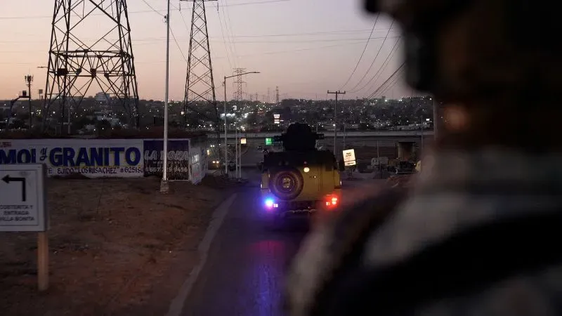 سيارة عسكرية تسير في منطقة سكنية في كولياكان، محاطة بأبراج كهرباء، في سياق الحرب ضد كارتل سينالوا وتجارة الفنتانيل.