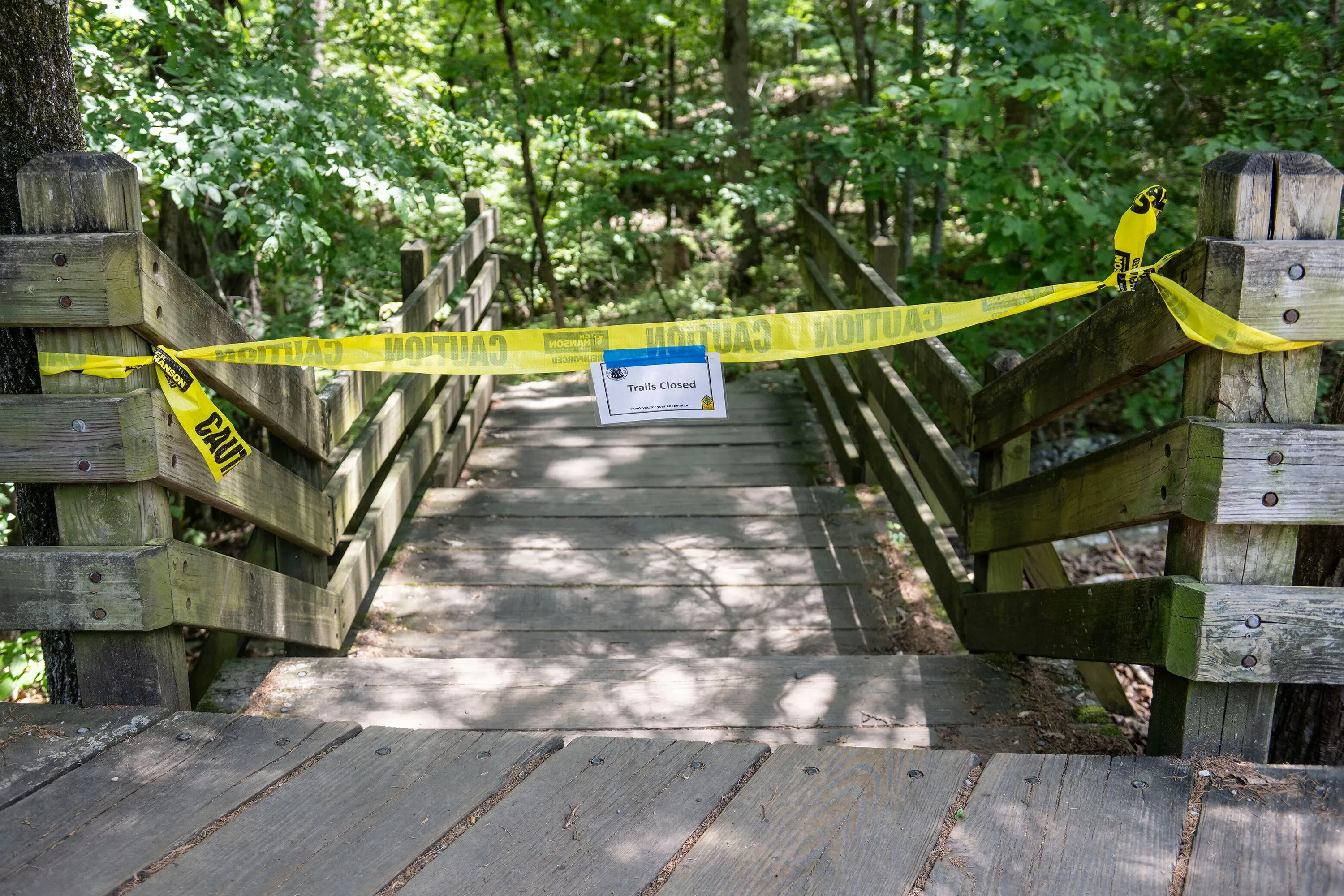 ممر مغلق في متنزه Devil's Den State Park، محاط بشريط تحذيري، بعد حادثة طعن مميتة تعرض لها زوجان أثناء نزهتهما مع أطفالهما.