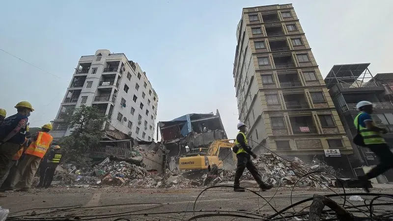 موقع زلزال ميانمار يظهر المباني المدمرة والعمال في موقع الحادث، مع التركيز على آثار الكارثة والحاجة الملحة للمساعدات الإنسانية.