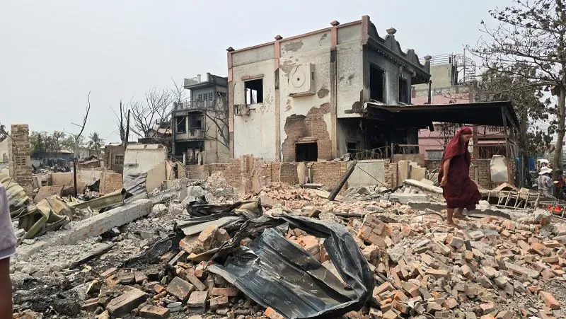 دمار واسع في ميانمار بعد زلزال بقوة 7.7 درجات، مع وجود شخص يتجول بين الأنقاض والمباني المدمرة.