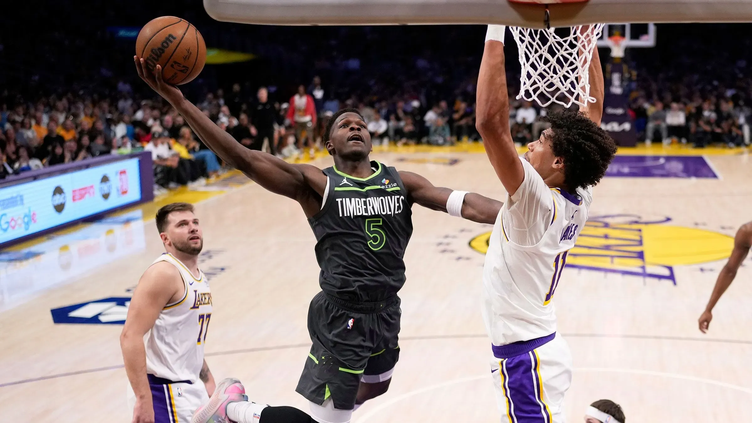 لاعب من فريق مينيسوتا تمبروولفز يسجل نقطة في مباراة ضد لوس أنجلوس ليكرز، مع تفاعل الجماهير في ملعب Crypto.Com Arena.