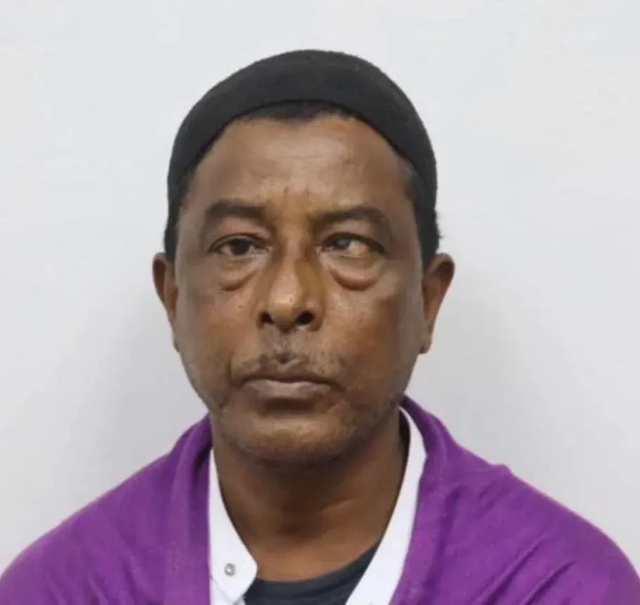 صورة لرجل في منتصف العمر، يعاني من ضعف البصر، يظهر تعبيره الجاد. الحادث يسلط الضوء على قضايا حقوق اللاجئين في الولايات المتحدة.