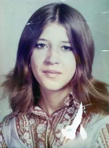 صورة لورا آن إيمي، مراهقة فقدت في عام 1974، تظهر فيها ملامحها الشابة وشعرها الطويل، تعكس براءتها قبل اختفائها المأساوي.