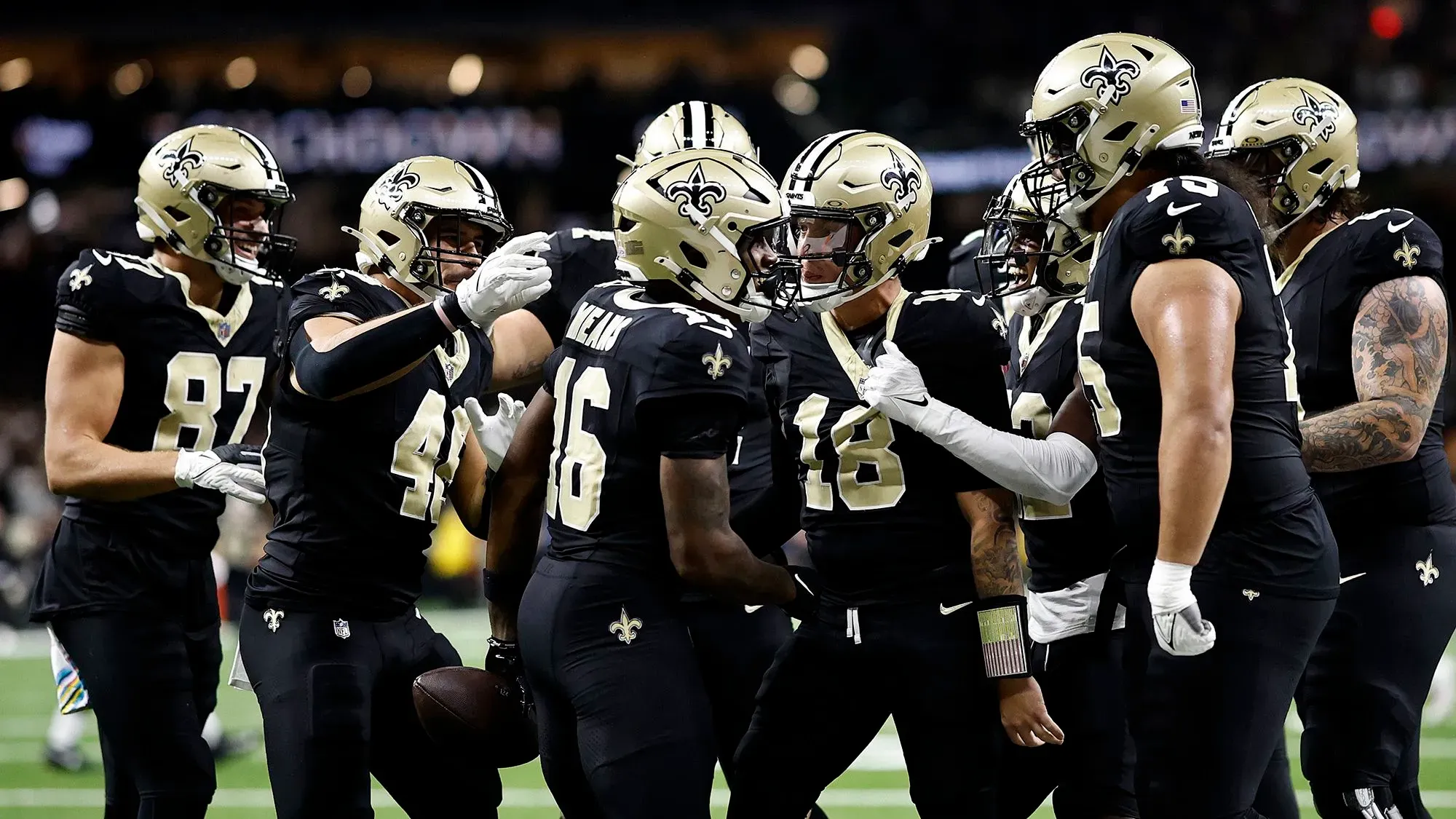 فريق نيو أورليانز ساينتس يحتفل بتسجيل هدف خلال مباراة في دوري كرة القدم الأمريكية، يرتدي اللاعبون زيهم الأسود المميز.