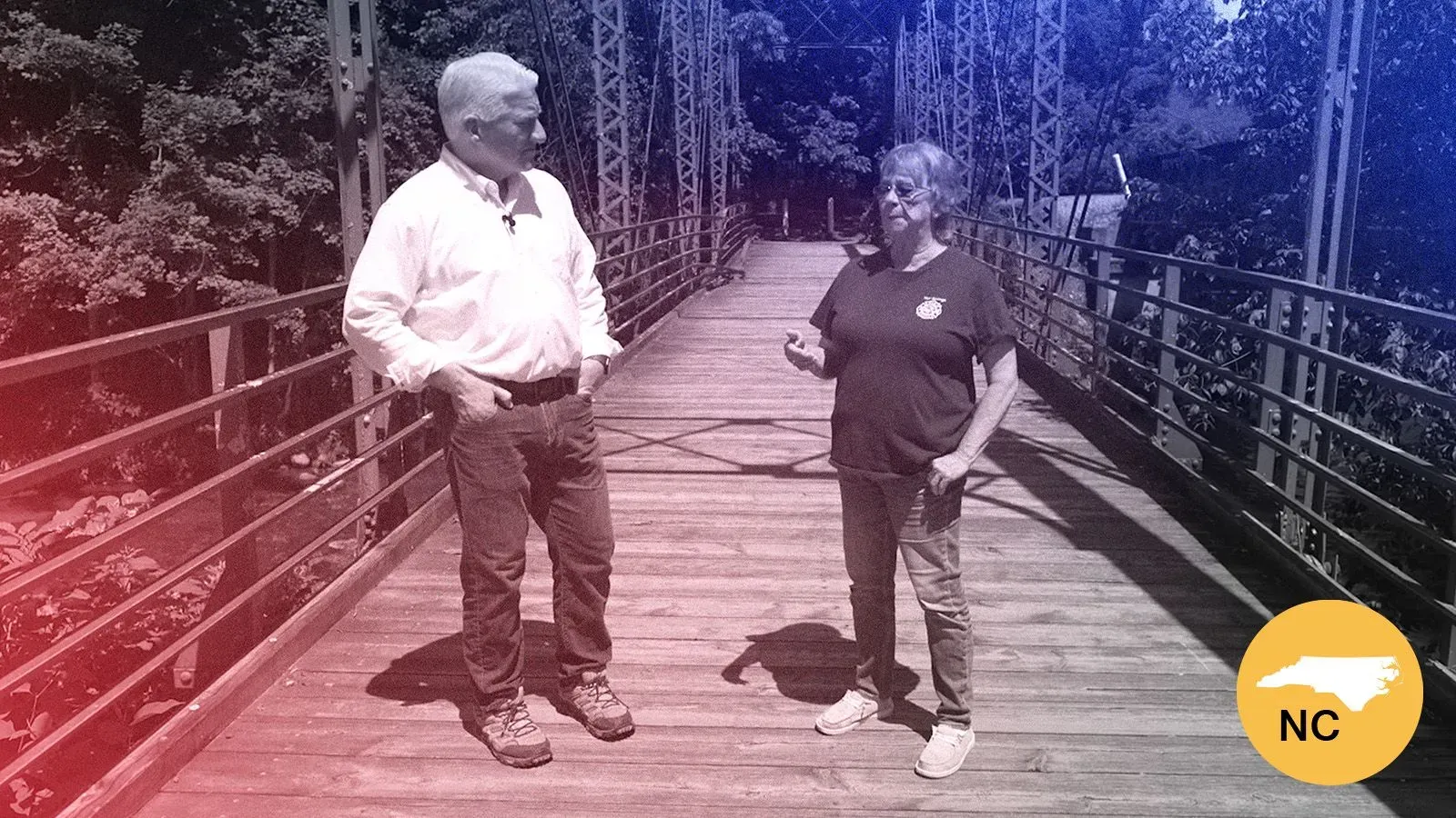 امرأة ورجل يتحدثان على جسر خشبي في شمال كارولينا، يعكسان تأثير إعصار هيلين على المجتمع المحلي واستجابة السكان.