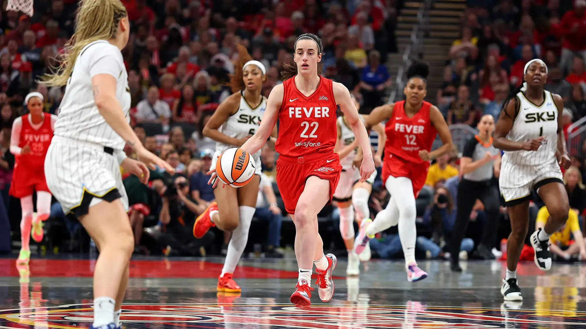 كيتلين كلارك، لاعبة إنديانا فيفر، تقود الكرة خلال مباراة ضد شيكاغو سكاي، وسط أجواء تنافسية في الدوري.