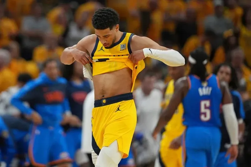 لاعب كرة سلة يرتدي زي فريق إنديانا بيسرز الأصفر، يقوم برفع قميصه خلال مباراة حماسية ضد أوكلاهوما سيتي ثاندر.
