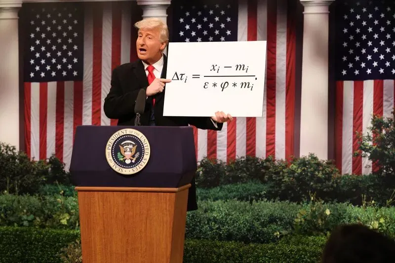 شخصية كوميدية تمثل رئيسًا سابقًا، تقدم معادلة رياضية على خشبة المسرح، مع خلفية من الأعلام الأمريكية، تعكس قضايا اقتصادية.