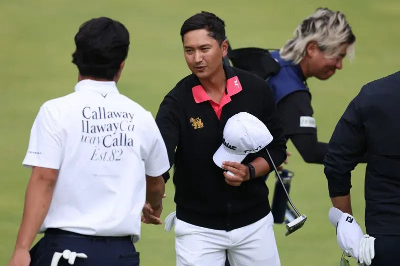 لاعب الجولف سادوم كايوكانجانا يتصافح مع زميله بعد جولة ناجحة في بطولة أيرلندا الشمالية المفتوحة وسط أجواء عاصفة.