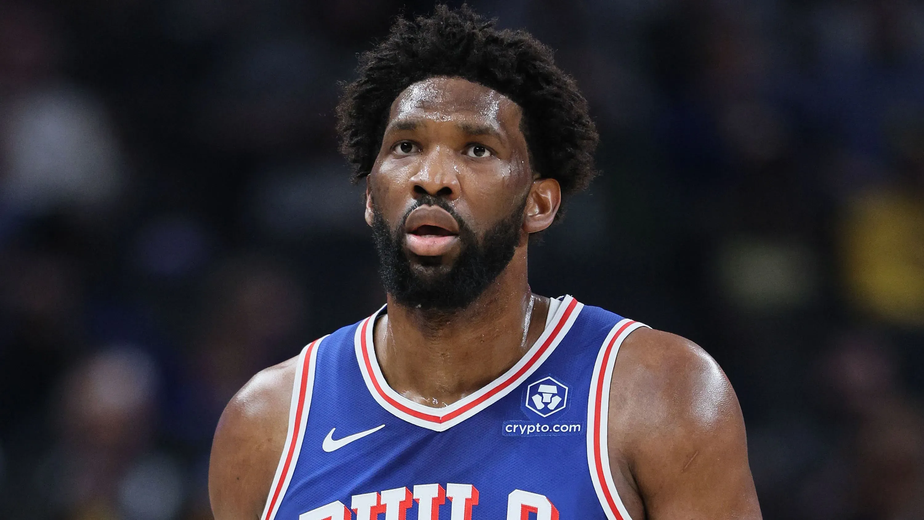 جويل إمبييد، نجم فريق فيلادلفيا 76ers، يظهر بملابس الفريق، مع تعبير وجه يعكس القلق بسبب إصابته في الركبة.